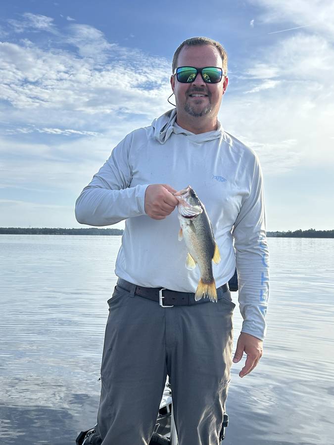Angler with a St. Johns River bass on a calm morning